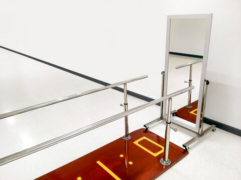 Rehab parallel bars with mirror in white room at rehabilitation center