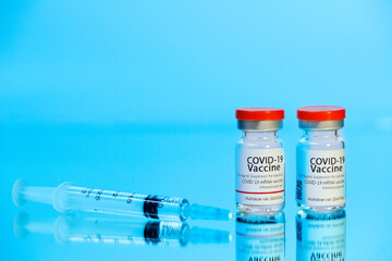 Ampoules with COVID-19 coronavirus vaccine, with a syringe for vaccination. 
