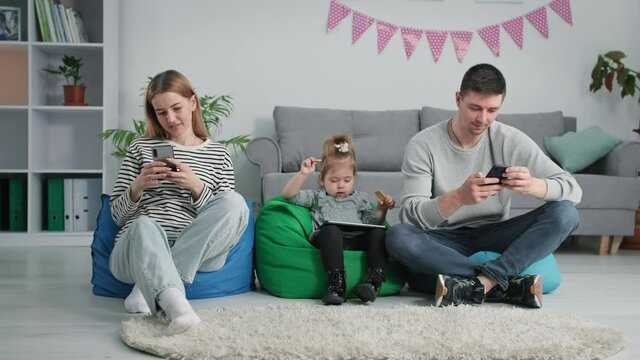 modern technologies, young family with a small child uses gadgets to view social networks while relaxing at home