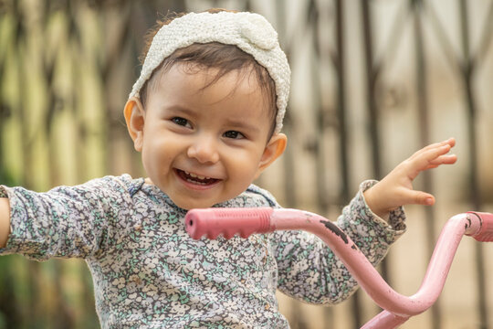 Cute toddler child, boy, playing with tricycle in park and eating apple, kid riding bike on sunset