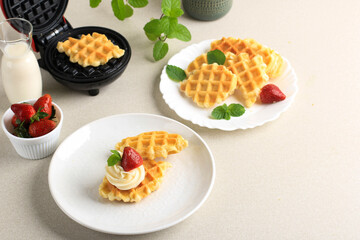 Fresh Made Delicious Homemade Croissant Waffle with Cream and Strawberry. on Top. Served on White Plate, Clean Background with Copy Space for Text