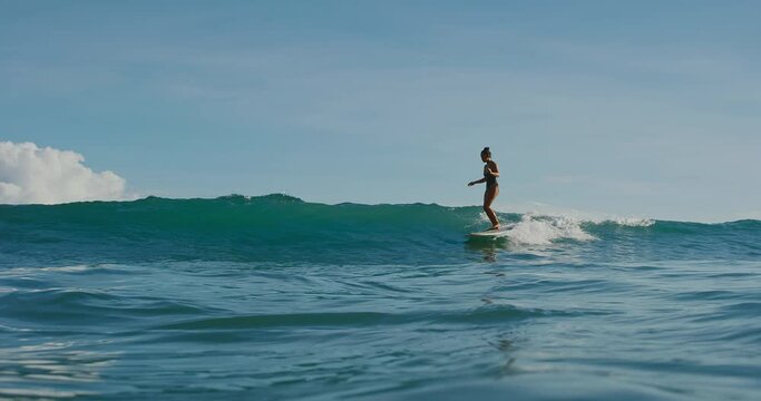 Beautiful Hawaiian surfer girl riding ocean wave, active lifestyle adventure outdoors