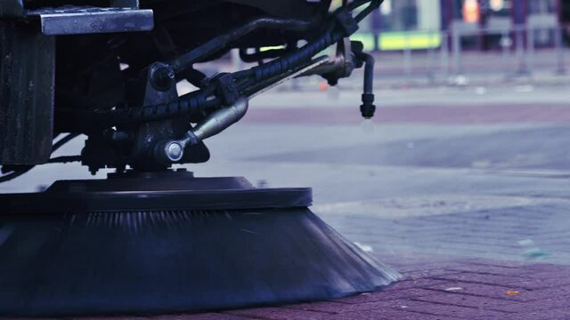 Close-up of a street sweeper in movement. cleaning truck, washing the pavement on street