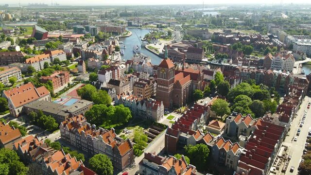 Aerial panorama of Old Town in Gdansk, flying over Church of Sts. John, Primary School No. 50, Nova Motlawa river embankment, Polish Baltic Frederic Chopin Philharmonic, Ferris wheel, Hotel KROLEWSKI
