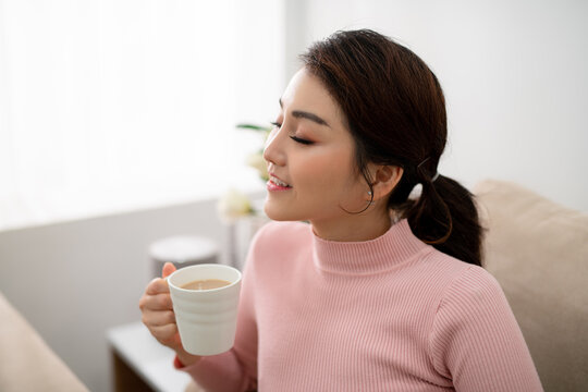 happy young woman with cup of tea at home