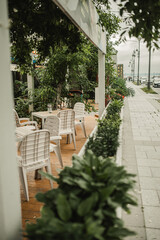 stylish outdoor cafe with wooden furniture and beautiful landscaping. use of plants in decor of restaurants. summer terrace. urban faces, selective focus