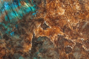 The texture of a mineral stone of labradorite or granite, shimmering with different colors, is...