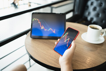 Man holding phone and looking at candlestick chart suitable for Stock market forex or cryptography trading financial investment graphs Finance Economy trends Trading Stock Concept
