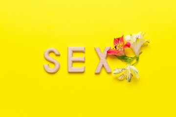 Word SEX with flowers on color background
