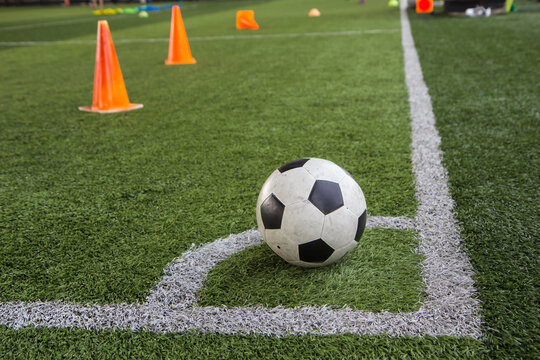 Soccer ball tactics on grass field with cone
