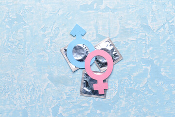 Female and male symbols with condoms on color background. Erotic concept