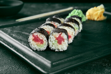 Maki sushi roll with salmon. Classic Japanese cuisine. Food delivery. Black background
