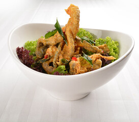 popular deep fried crispy salmon fish skin with salted egg yolk paste sauce in white background asian snack cuisine halal fast food menu