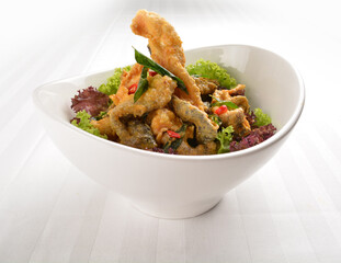 popular deep fried crispy salmon fish skin with salted egg yolk paste sauce in white background asian snack cuisine halal fast food menu