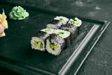 Maki sushi roll with avocado. Classic Japanese cuisine. Food delivery. Black background