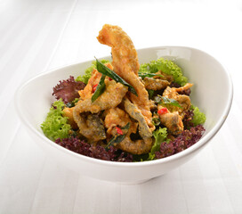 popular deep fried crispy salmon fish skin with salted egg yolk paste sauce in white background asian snack cuisine halal fast food menu