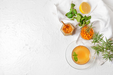 Cup of healthy sea buckthorn tea on white background