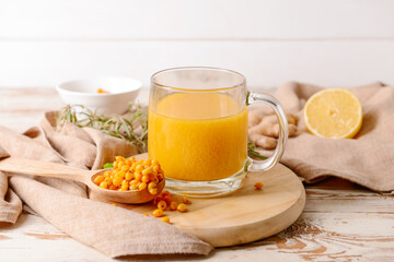 Cup of healthy sea buckthorn tea on table
