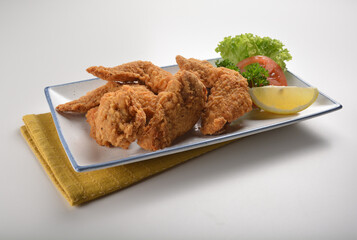 deep fried crispy golden chicken wings with tomato green salad in white background western snack cuisine halal fast food menu