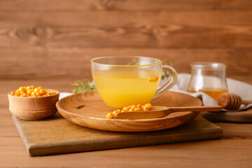 Cup of healthy sea buckthorn tea on table