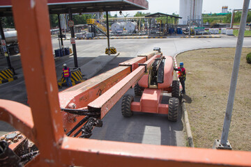 Male control boom lift in a industry working at high © chitsanupong