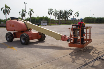 Male control boom lift in a industry working at high
