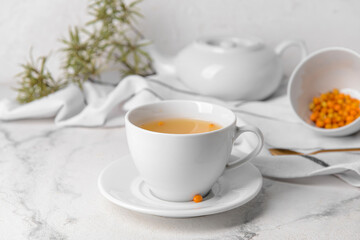 Fototapeta na wymiar Cup of healthy sea buckthorn tea on table