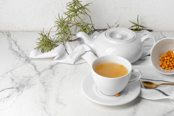 Cup of healthy sea buckthorn tea on table