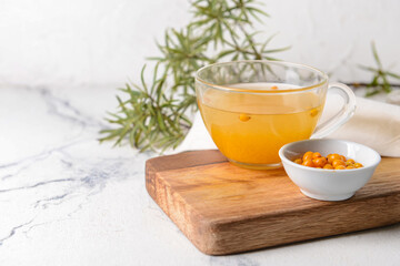 Cup of healthy sea buckthorn tea on table