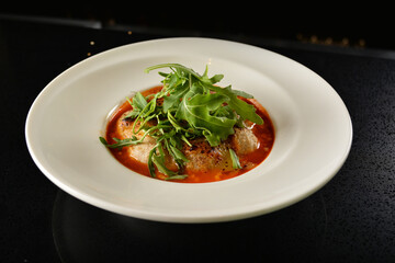 cheesy baked cheese meat ball with red tomato bolognese sauce and green vegetables in dark bar counter background western cuisine halal menu