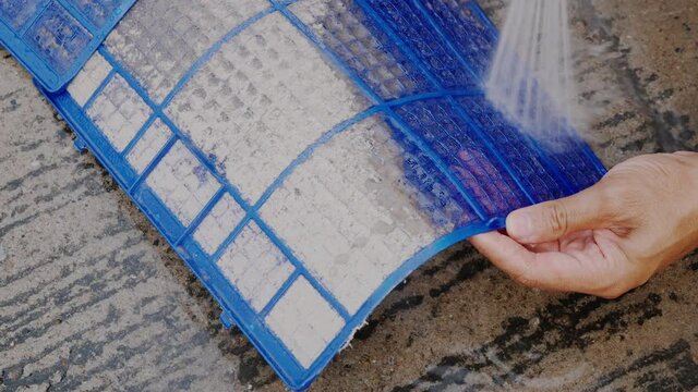 Technician service maintenance to cleaning dirty dust dense on filter air conditioner with water