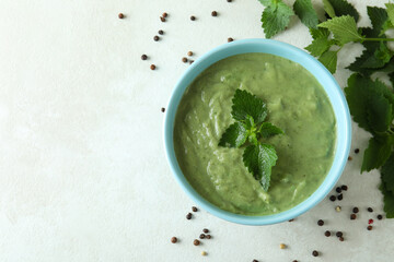 Concept of healthy food with nettle soup on white textured table