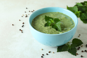 Concept of healthy food with nettle soup on white textured table
