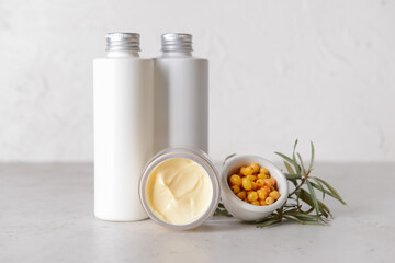 Healthy sea buckthorn cosmetics on grey background