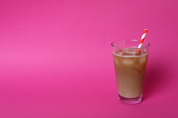 Glass of ice coffee on pink background