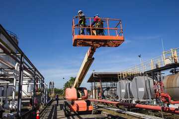 Two male  industry working at high in a boom lift © chitsanupong