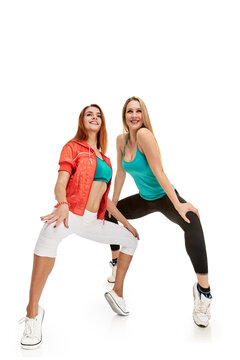 Full photo of two beautiful athletic sporty girls training together on white background