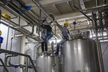 Male work the process of cream cosmetic fermentation at the manufacturing stainless tank