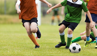 Group of youth football players running after ball. Young boys in a soccer game. School kids in a sports competition