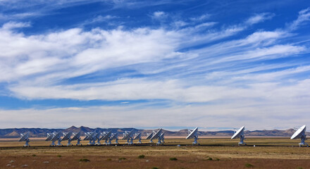 nineteen radio telescopes and giant dish antennas  in the karl g. jansky very large array radio astronomy observatory against a mountain backdrop  near socorro, new mexico