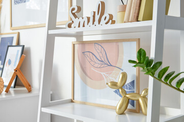 Book shelf with decor and picture near light wall