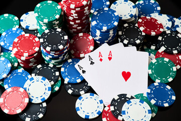 Stack of Casino gambling chips and cards isolated on black reflective background