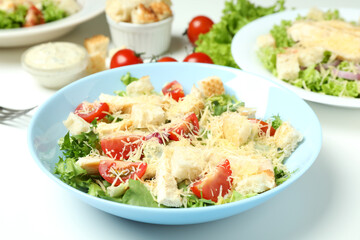 Fototapeta na wymiar Concept of tasty eating with Caesar salad on white background