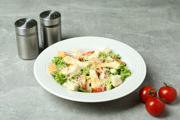 Concept of tasty eating with Caesar salad on gray textured background