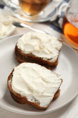 Bread with cream cheese on plate, closeup
