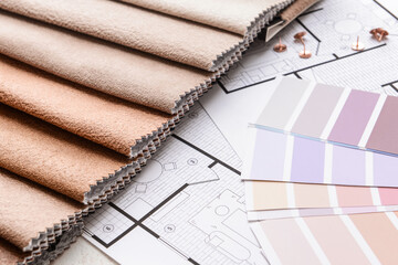 Paint color palettes and fabric samples on house plan, closeup
