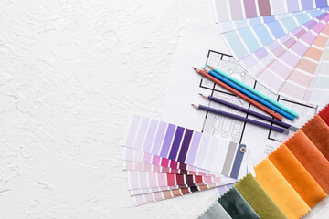 Composition with paint color palettes and fabric samples on white background