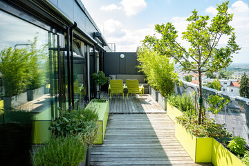 Dachterrasse mit Holzdeck, grüner Sitzbox, grünen Pflanzgefäßen und einem Lounge-bereich mit...