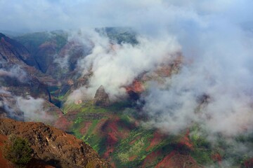  afternoon fog rolls in  over colorful  waimea canyon, kauai, hawaii      