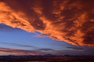 dramatic front of clouds moving in across long's peak and the front range at sunset, as seen from broomfield, colorado 